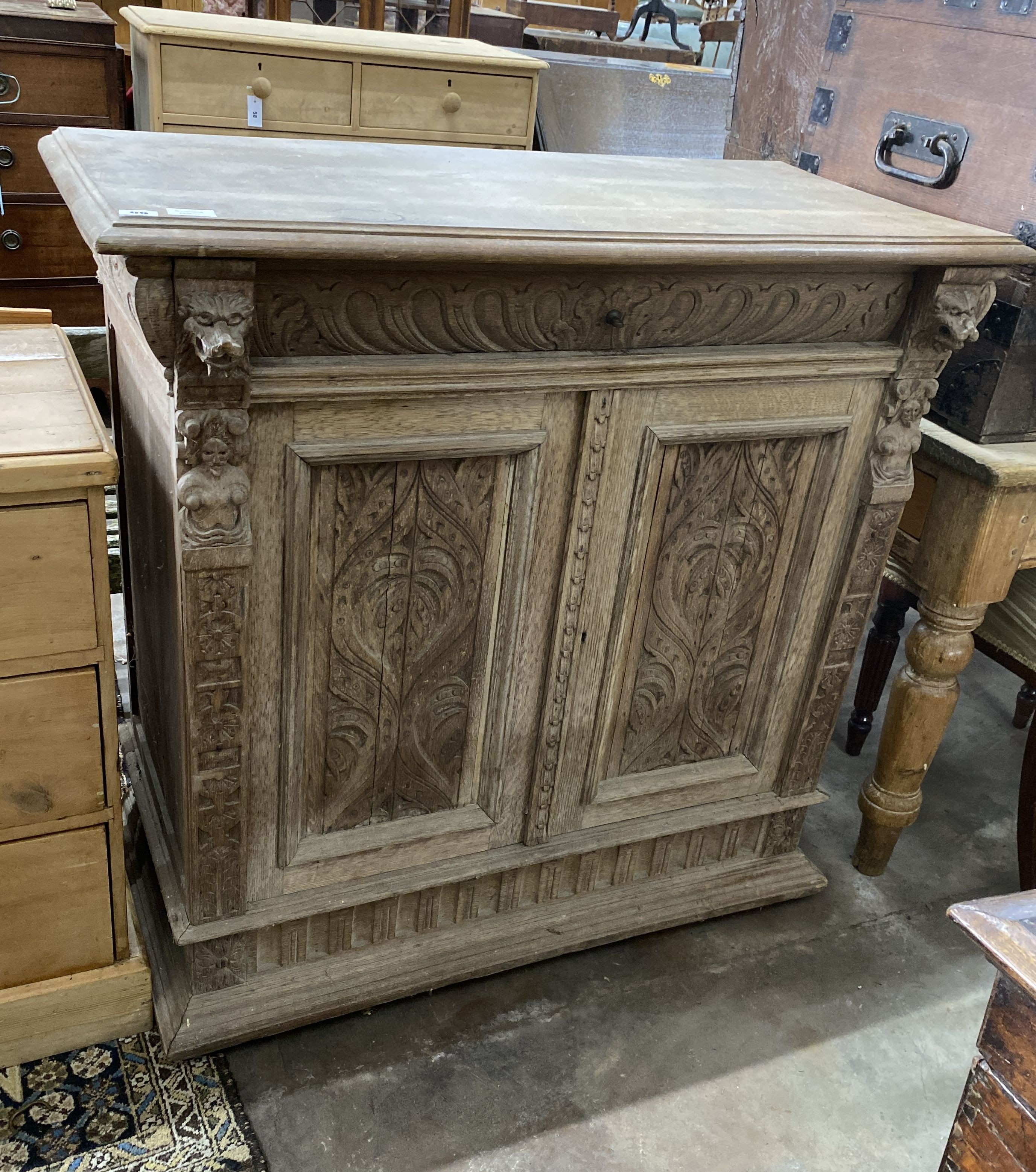 A late 19th century Flemish carved bleached oak two door side cabinet, width 106cm, depth 50cm, height 104cm